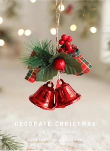 Detail of red Christmas bells with checkered bow, pine needles and berries for decoration