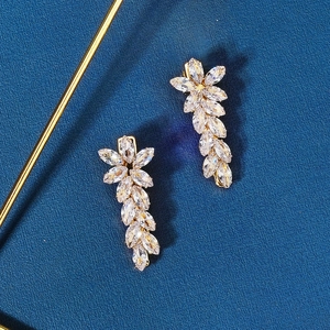 Detailed view of floral crystal earrings with golden metal petals and faceted gemstones