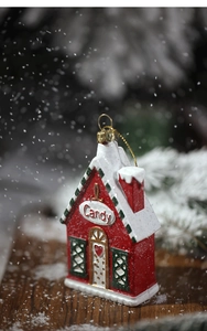 Detail of a candy house Christmas ornament with red and white festive patterns