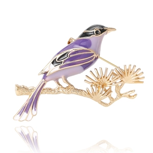 Elegant magpie and pine branch brooch with purple enamel finish and golden plating