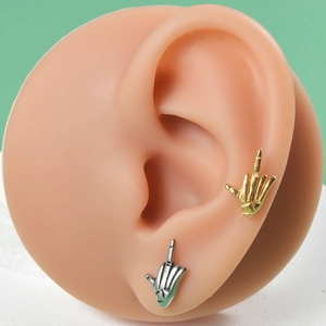 Detail shot of gold and silver I Love You hand gesture ear cuffs on model