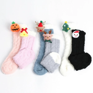 Detailansicht von drei Paar flauschigen Korallenfleece Weihnachtssocken mit 3D-Puppen