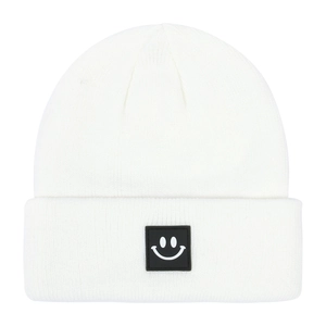 Dettaglio del berretto in maglia bianca per neonati con patch a faccina sorridente