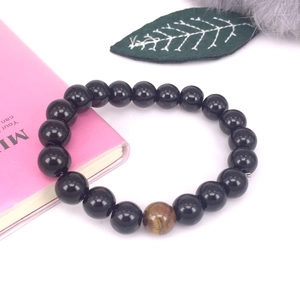 Primer plano detallado de la pulsera de hematita con una piedra de ojo de tigre marrón