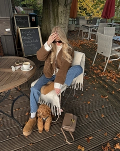 Lifestyle-foto van een bruine vintage gewatteerde jas met striksluiting op model
