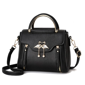 Chic black litchi leather handbag with gold ring handle and elegant pearl tassels