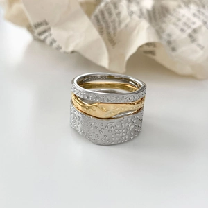 Three-piece stackable lava texture rings in gold and silver finish on white background