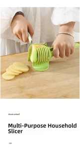 Green vegetable slicer guide tool holding a potato on a wooden board for safe cutting