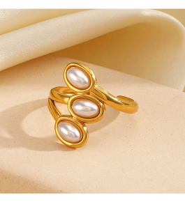 Macro detail of triple-layer gold spiral ring with three elegant white pearls