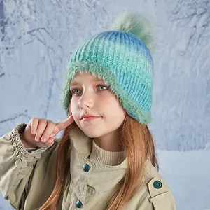 Winter knit hat for girls with colorful pompom and warm fleece lining in outdoor snow scene