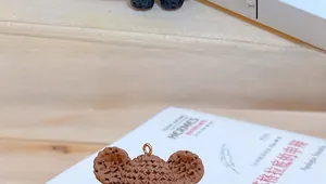 Detailed view of a brown resin animal pendant with geometric cutout texture and metal ring