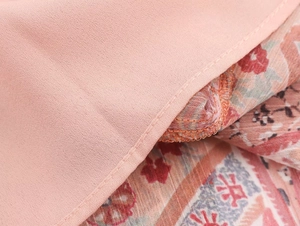 Dettaglio doppia cucitura e stampa paisley rosa boho su tessuto in chiffon leggero