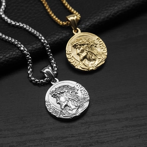 Close-up of gold and silver Ecce Homo Jesus relief pendant necklaces on textured background