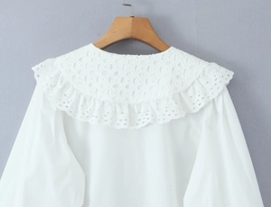 Close-up of exquisite hollow lace collar and cotton texture on white long sleeve shirt