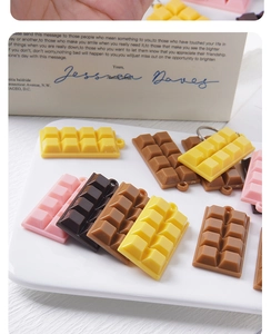 Detail of realistic chocolate bar resin pendants in assorted colors on a ceramic tray