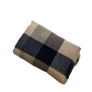 Folded blue and beige checkered plaid scarf with tassel edges on a white background
