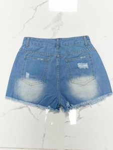 Rear view of light blue denim shorts with distressed pockets and raw frayed hem edges