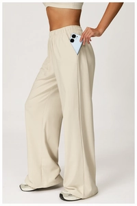 Detail showing the deep side pocket of beige high-waisted wide-leg sweatpants with a phone