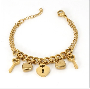 Détail d'un bracelet double couche plaqué or 18K avec pendentifs en forme de cœur et de clé