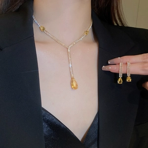 Détail du collier goutte en cristal jaune et boucles d'oreilles sur un mannequin