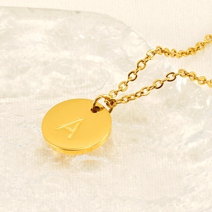 Polished gold stainless steel necklace with round pendant featuring engraved letter A
