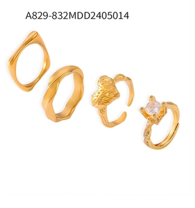 Ensemble de quatre bagues plaquées or aux textures géométriques et pierre de zircon brillant