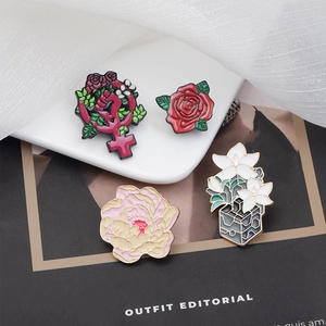 Creative floral enamel pin set with roses and lilies on a stylish black magazine cover