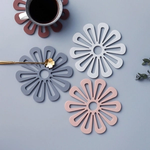 Detailed macro view of floral silicone table mats in grey and white for heat protection