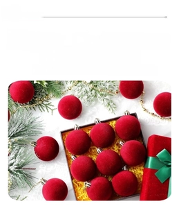 Detail of red flocked Christmas balls with metallic hooks in festive gift packaging set