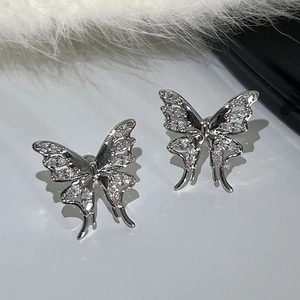 Elegant silver butterfly ear cuff set with sparkling cubic zirconia on a white feather background