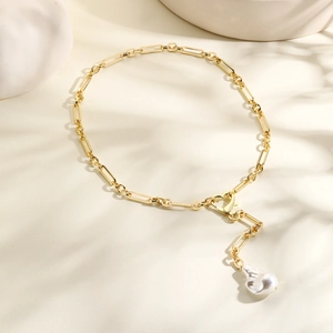 Detail of gold paperclip chain necklace with heart clasp and baroque pearl pendant