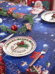 Detail of Christmas tablecloth featuring snowflakes and festive greenery holiday decor