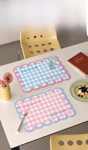 Detail of checkered placemats with wave edges in blue and pink for dining tables