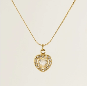 Close-up of golden heart necklace with large central zircon and halo of small stones