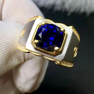 Macro shot of two-tone ring featuring a large blue gemstone and gold screw accents