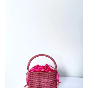 Detail of woven fuchsia rhinestone evening bucket bag with satin lining and pearl charm