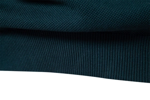 Nahaufnahme von dunkelblauem Strick mit Wabenstruktur und geripptem Bündchen-Detail