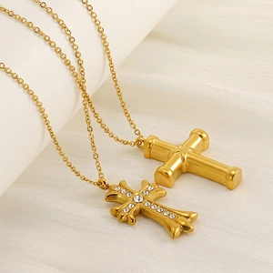 Gold stainless steel cross pendant necklaces with zircon crystals on silk background