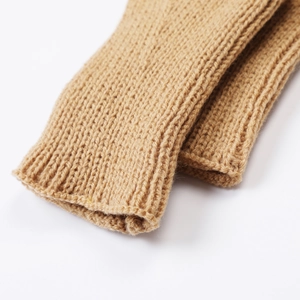 Detailed texture of camel knit fingerless gloves with ribbed cuffs and scale pattern