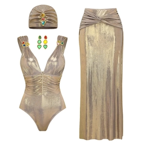 Metallic gold cutout one-piece swimsuit set with colorful gemstones and matching maxi skirt