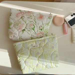 Detail of quilted cotton makeup bag with floral patterns and zipper closure
