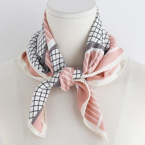 Detail of pink and grey geometric silk scarf tied on neck with elegant pattern