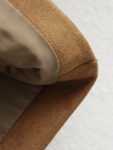 Détail macro du daim marron et de la couture de doublure beige sur une veste vintage