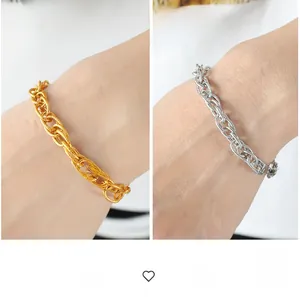 Detail of chunky interlinked chain bracelets in gold and silver with textured finish