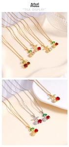 Detailed tile display of red cherry pendant necklace with green leaf stones and thin chain