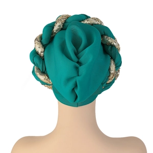Detail view of teal pleated turban with gold sequin braid on premium textured fabric