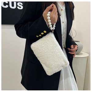 Close-up of white faux fur handbag featuring elegant pearl bead handles held by a model