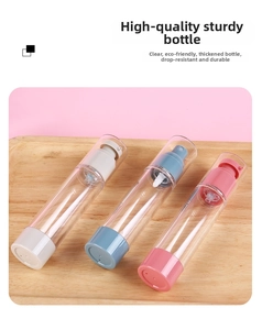 Three refillable vacuum spray bottles in gray, blue, and pink on a light wooden tray