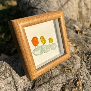 Détail d'art en verre de mer avec des oiseaux colorés sur verre dépoli et cadre en bois