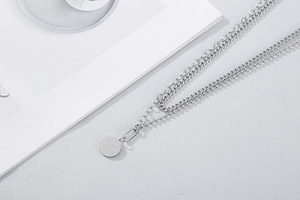 Detail of silver double layer necklace with Good Lucky engraved round pendant